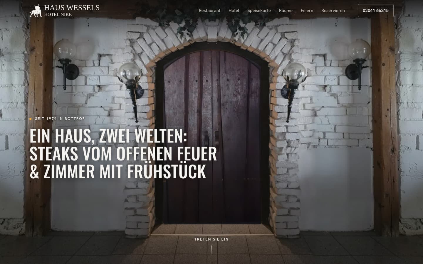 Startseite von Haus Wessels / Hotel Nike in Bottrop am Desktop: Foto einer Holztür in einem Ziegelbogen, Überschrift 'Ein Haus, zwei Welten: Steaks vom offenen Feuer & Zimmer mit Frühstück', Navigation zu Restaurant, Hotel, Speisekarte, Räume, Feiern und Reservieren.